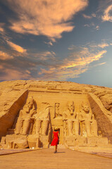 A European tourist in red dress walking towards the Abu Simbel Temple in southern Egypt in Nubia...