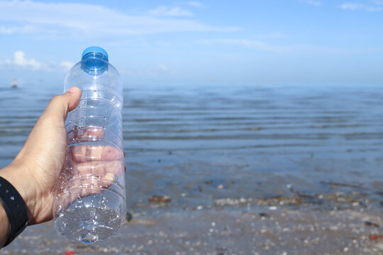 Hand Keep Cleanup The Plastic Bottle On Beach. Ecology Concept