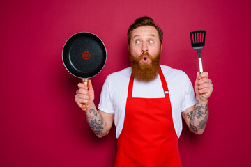 surprised chef with beard and red apron is ready to cook - obrazy, fototapety, plakaty