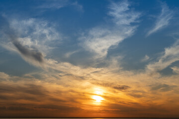 Calm on the coast. The sky in the evening. Water. Sunset sky on the coast. Golden hour. Sky and clouds. Feather cloud. The sun went down below the horizon. Evening sky background. Sunrise landscape