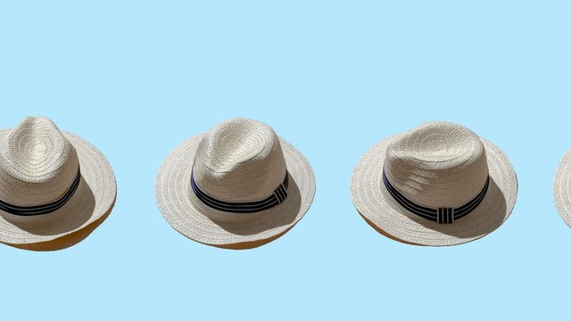 white straw wicker hat on a blue color background. seamless looping animation with hard shadows of the sun. minimal concept of travel and vacation