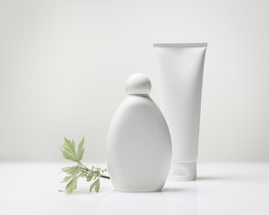 White plastic cosmetic bottle and tube with reflection on a white background with copy space. Beauty product, cosmetic, hygiene mockup for your design and label. Concept of natural, clean cosmetics