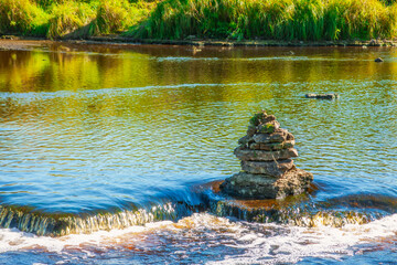 Tourists built a pyramid of small stones in the middle of the river.