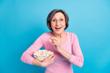 Photo of happy excited amazed shocked amazed woman eat popcorn hear good news isolated on blue color background