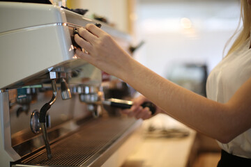 Close-up of Beautiful woman using coffee machine in kitchen