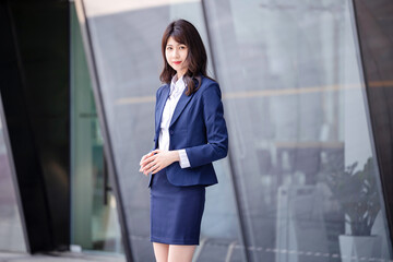 Beautiful Asian woman outdoors, wearing a suit