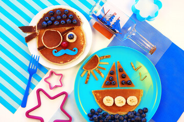 Fun food. Pancakes with berries for kids. pirate and ship boat. Breakfast for children. 