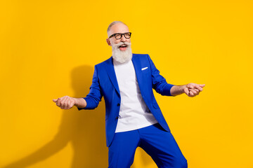 Photo of funky grey beard senior man look empty space wear spectacles blue jacket isolated on vivid yellow color background