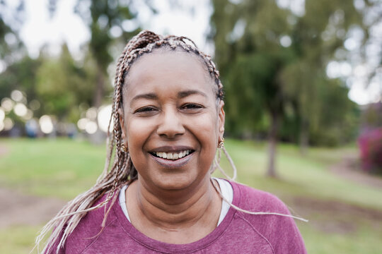 African senior woman smiling on camera at city park