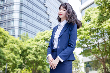 Beautiful Asian woman outdoors, wearing a suit