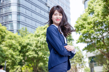 Beautiful Asian woman outdoors, wearing a suit