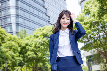 Beautiful Asian woman outdoors, wearing a suit