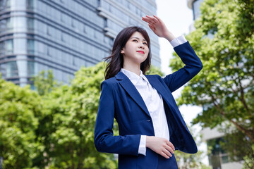Beautiful Asian woman outdoors, wearing a suit
