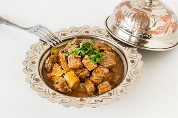 The Sacrifice Festival Food From Turkish Cuisine is Tas Kebabi stew made with beef in vintage plate with fork