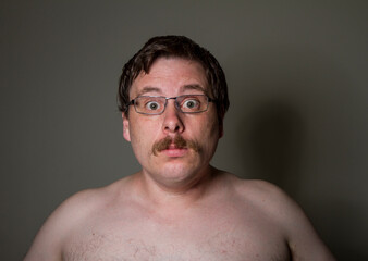 scared naked man wearing glasses
