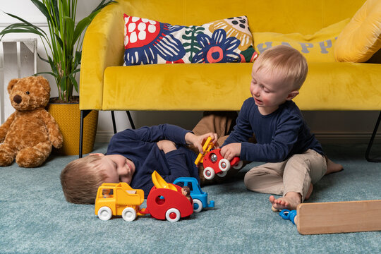 Two Brothers Fighting Over Toys, Sitting And Playing Cars Together - Blonde Caucasian Boys Spending Time At Home