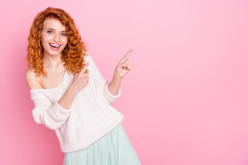 Photo portrait of curly girl amazed pointing finger choosing selecting empty space isolated pastel pink color background