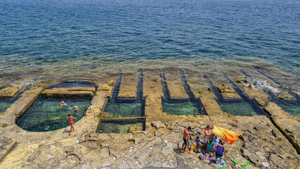 Fond Ghadir Beach,, Sliema, Malta - June 20th 2021: Man made rock pools commonly referred to as...