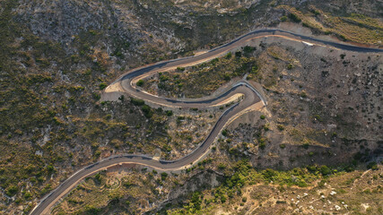 Aerial drone top down photo of serpentine winding asphalt road forming an 