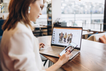 Beautiful Young Freelancer Woman Using Laptop Computer Sitting At Cafe Table. Happy Smiling Girl Working Online Or Studying And Learning While Using Notebook. Freelance Work, Business People Concept