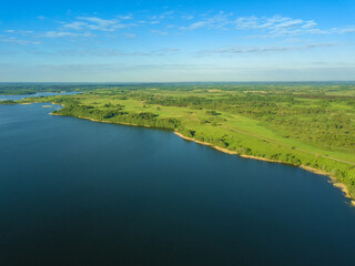 Beautiful aerial landscape on the lake with a drone. Many lake islands covered with forests, fields on a sunny day