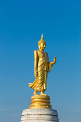 Fototapeta na wymiar The standing buddha with blue sky and cloud,Copy space