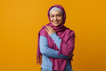 Middle eastern woman in headscarf smiling and looking at camera