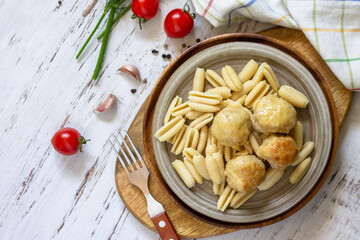 Italian pasta, keto diet lunch. Spaghetti with meatballs in cheese sauce on a wooden table. Top view, flat lay background. Copy space.