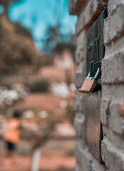 A selective focus shot of a padlock in a park with  blurred background, brown