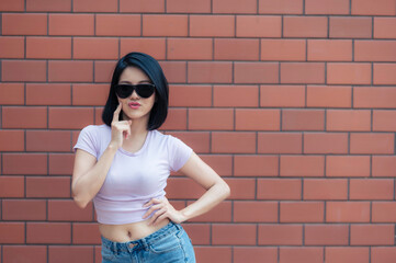 Portrait of hipster girl  on brick wall background,Beautiful asian woman pose for take a photo