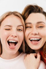 Young european two women laughing and winking at camera