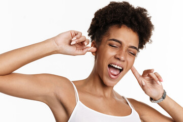 Young black woman in tank top screaming and plugging her ears