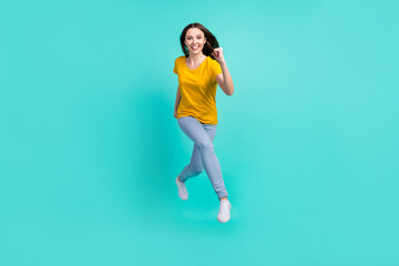 Fototapeta na wymiar Full size photo of funny young lady run wear yellow t-shirt jeans isolated on teal color background