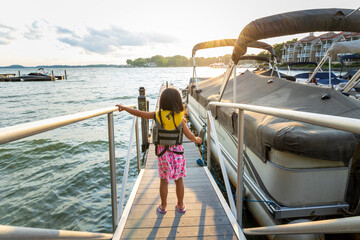 Young girl walking down a dock, looking forward to a boat ride, Lake Norman, NC
