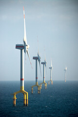 Offshore wind farm turbines at dusk in the middle of the sea