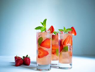 Three glasses of strawberry mojito with mint on the white background