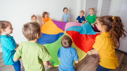 Children stretching colorful parachute for fun team games