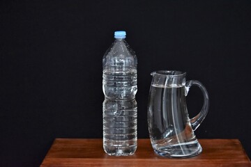 glass decanter and plastic water bottle on table
