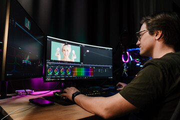 Back view of a young white man video editor