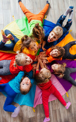 Cheerful children playing team building games on a floor - 441443307