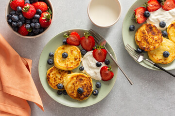 Cottage Cheese Pancake with strawberries, blueberries and sour cream, mug with milk and fresh berries, delicious breakfast, top view