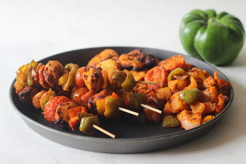 Air fried chicken and bell peppers in skewers. Boneless chicken cubes marinated with yogurt and spices and Air fried along with bell peppers.
