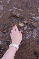 
hand with a bracelet in the water