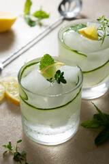 Cold drinks with cucumber, lemon and ice. Summer refreshing lemonade.