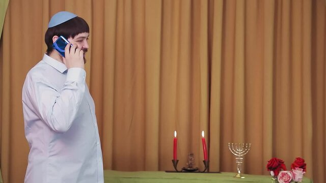 Before the chuppah ceremony, the Jewish groom speaks on the phone in the synagogue hall