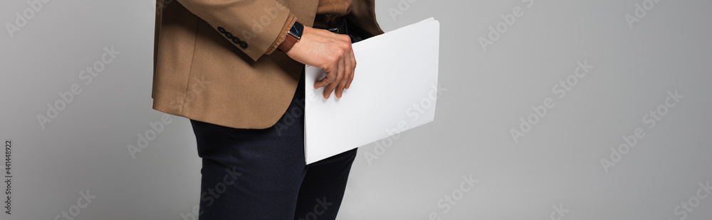 Wall mural cropped view of businessman holding paperwork isolated on grey, banner