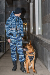 Female police officers with a trained dog. German shepherd police dog.