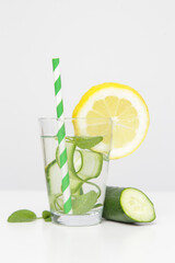 Fototapeta premium Lemon cucumber water with colorful paper straw. Healthy detox drink.