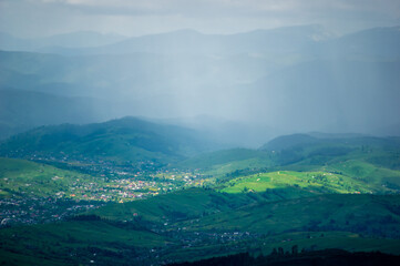Naklejka premium The village among the mountains in the sun and rain