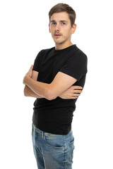 Young handsome tall slim white man with brown hair with crossed arms turned sideways in black shirt in blue jeans isolated on white background